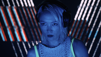 Une femme illuminée d'une lumière bleue néon porte un casque de DJ sur les oreilles dans Mi Amor de Guillaume Nicloux