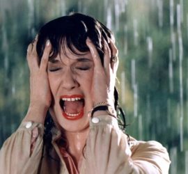 Daria Nicolodi, trempée par la pluie, hurle de peur dans le film Ténèbres de Dario Argento.