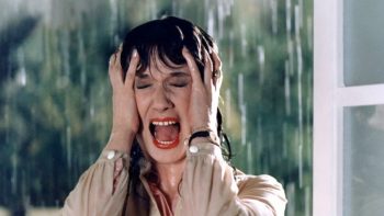 Daria Nicolodi, trempée par la pluie, hurle de peur dans le film Ténèbres de Dario Argento.