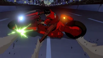 De nuit, un jeune homme en rouge lance sa moto à pleine vitesse sur une autoroute déserte ; couché sur le guidon, il négocie un virage serré : la moto dérape presque à l’horizontale, ses roues chassent sur l’asphalte tandis qu’une pièce métallique frotte le sol dans une gerbe d’étincelles ; au loin scintillent les gratte-ciel de la ville ; plan du film d'animation japonais AKIRA.