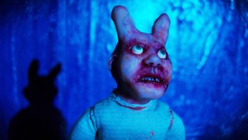 Créature en stop motion en forme de lapin ; visqueux avec des yeux bleus ; regardant vers le haut dans un fond bleu ; image issu de bobby yeah de Robert Morgan.