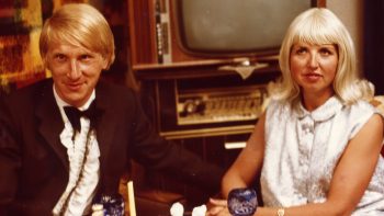Un couple allemand blond ; assis côte à côte devant un vieux téléviseur ; plan issu du film Die Bettwurst de Rosa Von Praunheim.
