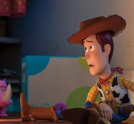Woody assis seul au milieu des jouets dans Toy Story 4.