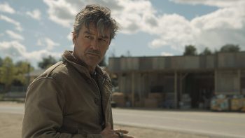 Kyle Chandler ; interprète de Hal Jordan ; regarde vers sa gauche dans une ville qui semble déserte ; plan issu de la série Lanterns.