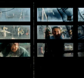 Des personnages observent une menace à travers les vitres d'un bâtiment dans le film Hope de Na Hong-jin.