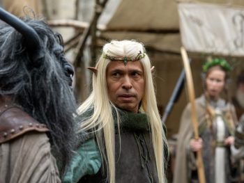 Éric Judor, vêtu d'un costume médiéval et portant une longue perruque blonde ainsi qu'un diadème, incarne un personnage elfique dans Le Roi du Game.