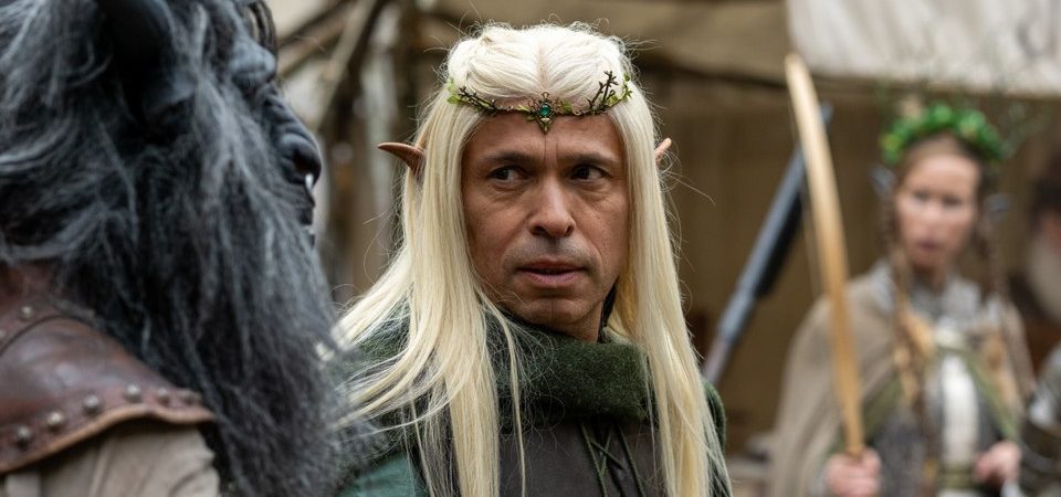 Éric Judor, vêtu d'un costume médiéval et portant une longue perruque blonde ainsi qu'un diadème, incarne un personnage elfique dans Le Roi du Game.